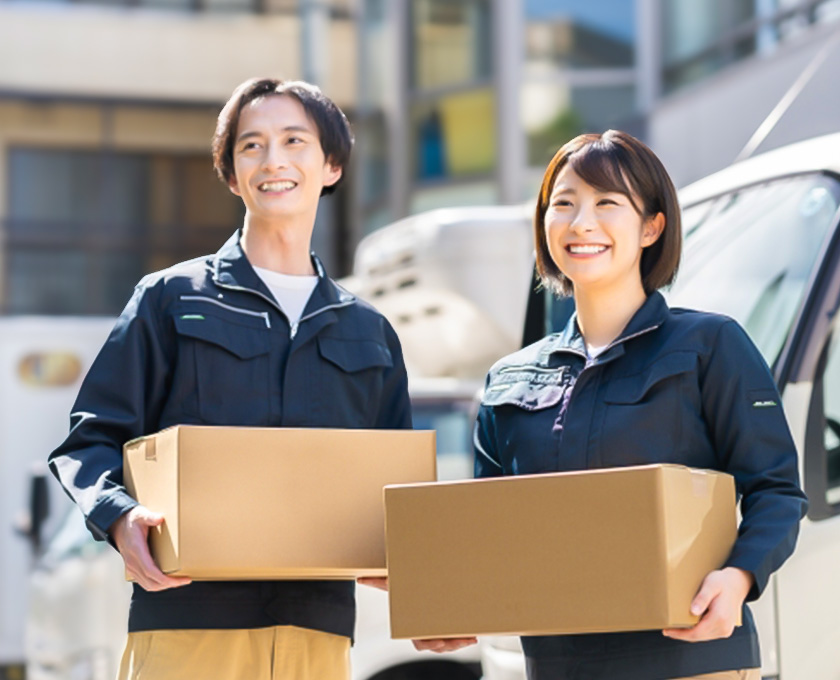笑顔で荷物を運ぶ配達員の男女